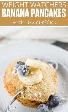 blueberry pancakes with bananas and powdered sugar on a white plate, with text overlay reading weight watchers banana pancakes with blueberries