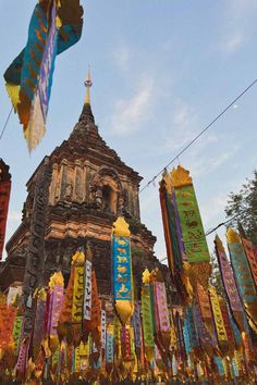 many colorful banners are hanging in front of a building with a steeple on top