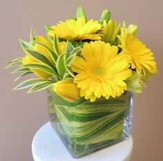 a vase filled with yellow flowers on top of a table