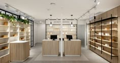 the interior of a store with wooden shelves and shelvings on both sides, along with computer desks