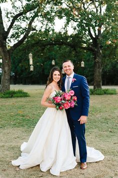 a bride and groom pose for a photo in front of some trees at their wedding