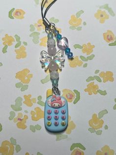 a cell phone charm is hanging from a cord