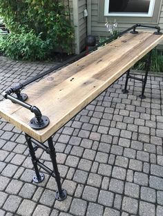 a long wooden bench sitting on top of a brick walkway