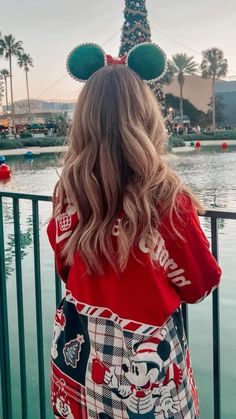 the back of a woman's head wearing mickey mouse ears at disney world in florida