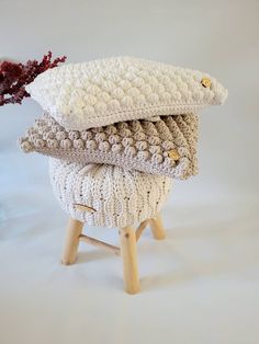 three knitted pillows stacked on top of each other