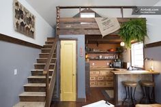 a kitchen with stairs leading up to the loft