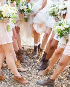 a group of women standing next to each other in short skirts and boots holding bouquets