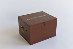 a brown box with the words camera museum on it sitting on a white surface next to a pair of scissors