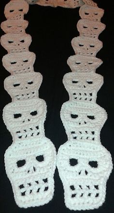 two crocheted white and pink necklaces on a black background