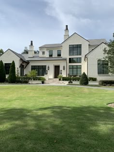 a large white house sitting on top of a lush green field