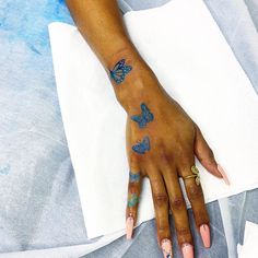 a woman's hand with butterfly tattoos on it