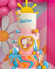 a multi - tiered cake with colorful decorations and balloons