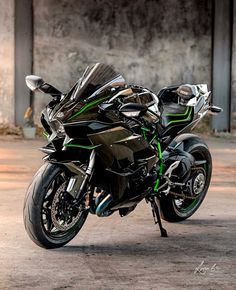 a black and green motorcycle parked in front of a building