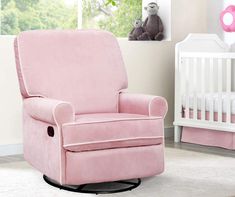 a baby's room with a pink chair and crib