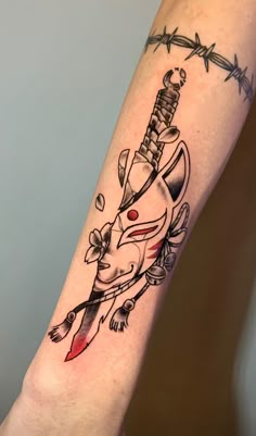 a tattoo on the arm of a woman with barbed wire behind her and an elephant holding a knife