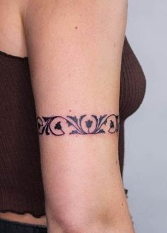 a woman's arm with a tattoo design on the left side of her arm