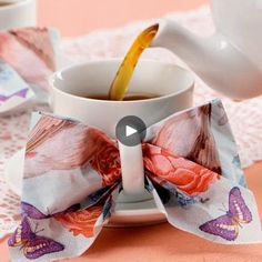 tea being poured into a white cup on a pink tablecloth with butterfly napkins