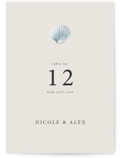 the wedding table numbers are displayed on top of a card that reads 12 and has an image of a seashell