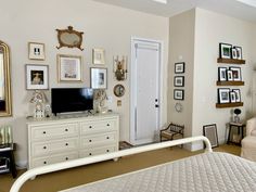 a living room filled with furniture and framed pictures on the wall next to a flat screen tv