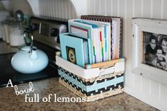 a stack of books sitting on top of a counter next to a white framed photo