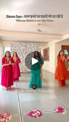 three women in long dresses are dancing on the dancefloor with flowers around them