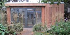 a small wooden building surrounded by plants and trees