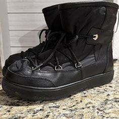 a pair of black boots sitting on top of a counter