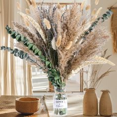 a vase filled with dried flowers on top of a table