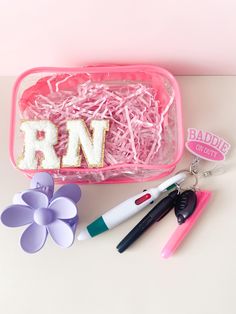 a pink case with letters and scissors on it, along with other items to make letter magnets