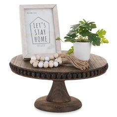 a potted plant sitting on top of a wooden table next to a white frame