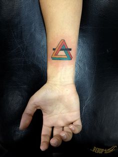 a hand with a triangle tattoo on it