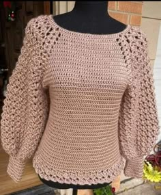 a crocheted sweater is shown on a mannequin