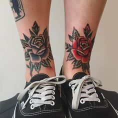 a woman's legs with tattoos and flowers on her ankles, both wearing tennis shoes