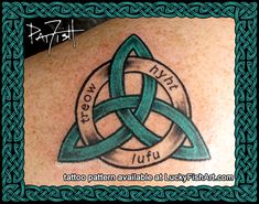 a celtic tattoo on the back of a woman's shoulder