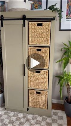 a small cabinet with wicker baskets on the front and bottom drawers, sitting next to a potted plant