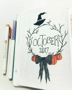 an open notebook with the words october written on it and pumpkins in front of it