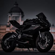 a black motorcycle parked in front of a building with a dome on it's roof