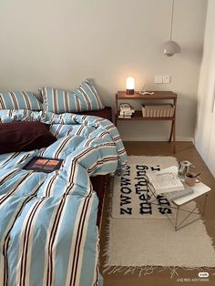 a bed room with a neatly made bed next to a night stand and a lamp