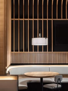 a table and chairs in a room with wooden partitions on the wall behind them