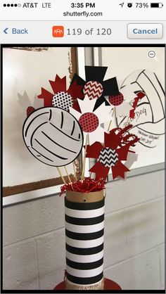 a vase filled with red and black paper flowers