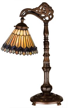 a lamp that is sitting on top of a wooden stand with a glass shade over it