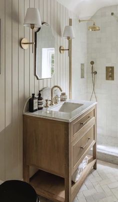 a bathroom with a sink, mirror and shower