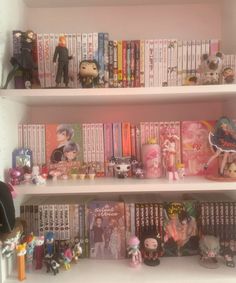 a book shelf filled with lots of anime figurines on top of white shelves