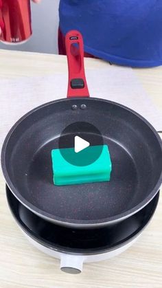 a frying pan with an appliance on the side sitting on a table