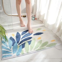 a person standing on a bathroom rug in front of a shower