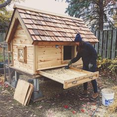 a woman is building a chicken coop out of wood and shinnels with her hands