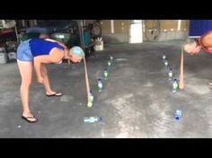 two women are bending over to pick up bottles