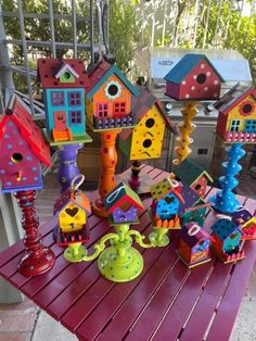 colorful birdhouses and telephones on a table outside