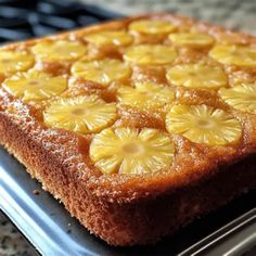 a close up of a cake on a pan with pineapples cut in half