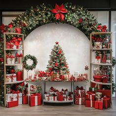 a christmas tree surrounded by presents under a decorated arch